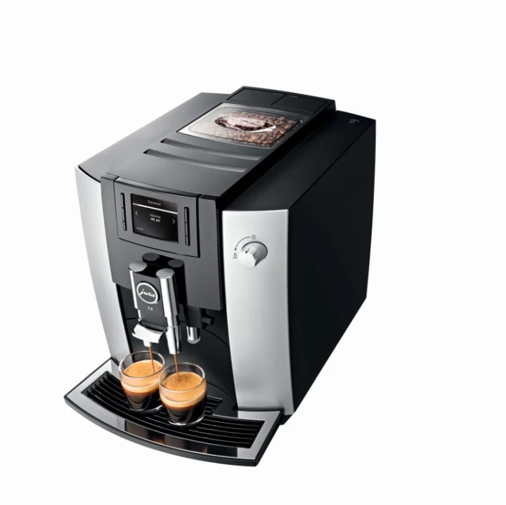 Ekspres Jura E6 EB w kolorze Platin, zaprezentowany od góry z prawej strony w czasie wykonywania dwóch kaw espresso, widok na pokrywę młynka