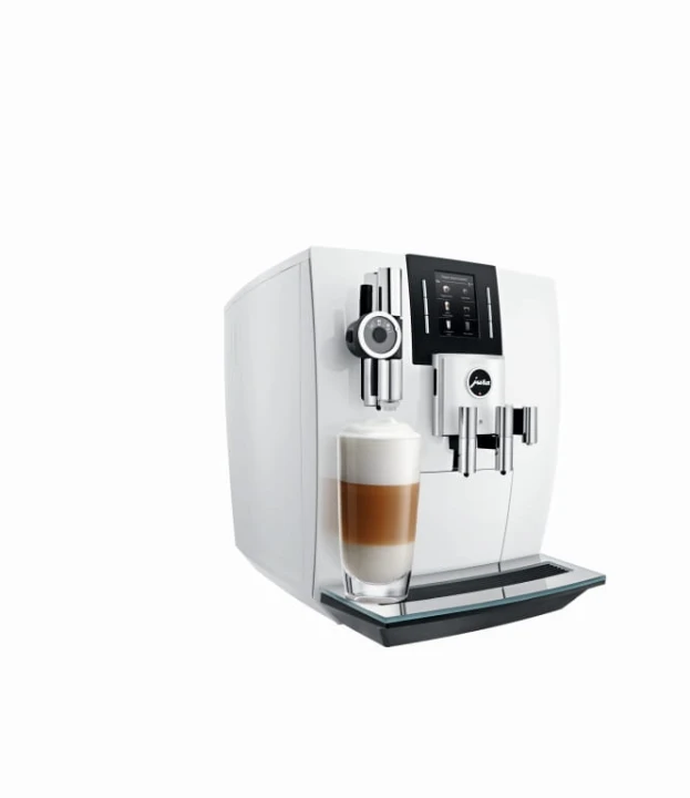 Ekspres Jura J6 w kolorze Piano White, zaprezentowany od lewej strony, z kawą latte macchiato