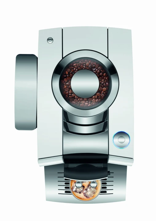 Ekspres Jura Z10 w kolorze Diamond White - błyszczącej bieli, zaprezentowany od góry, z widokiem na zbiornik ziaren oraz rotary switch, ze szklanką kawy Cold-brew