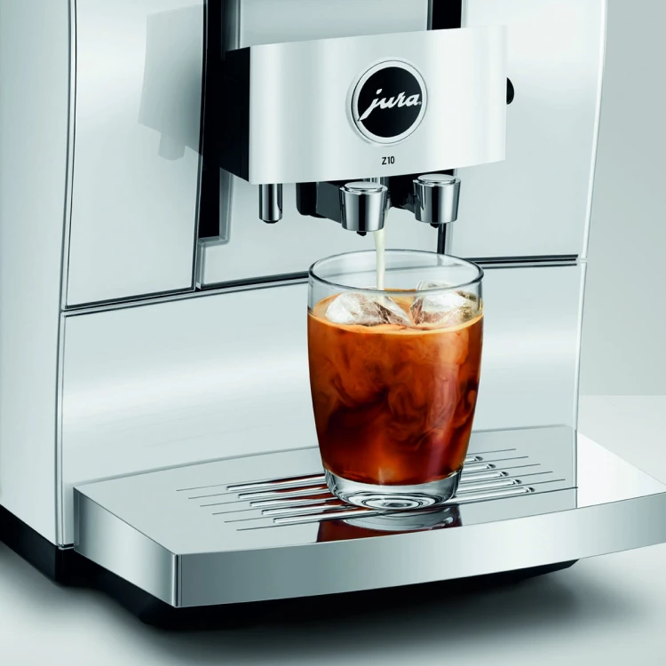 Ekspres Jura Z10 w kolorze Diamond White - błyszczącej bieli, zaprezentowany ze szklanką kawy Cold-brew