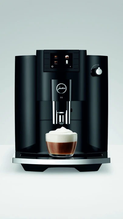 Ekspres Jura E6 EC w kolorze Piano Black, zaprezentowany od frontu z kawą cappuccino
