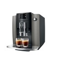 Ekspres Jura E6 EB w kolorze Dark Inox, zaprezentowany od prawej strony z dwiema kawami espresso
