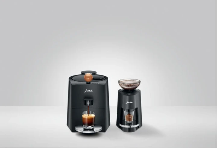 Ekspres Jura ONO w kolorze Coffee Black, zaprezentowany z wolnostojącym  młynkiem PAG