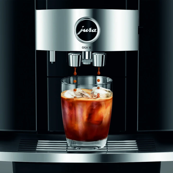 Ekspres Jura GIGA 10 w kolorze Diamond Black - błyszczącej czerni, zbliżenie na wylewkę ekspresu w trakcie wykonywania kawy cold-brew