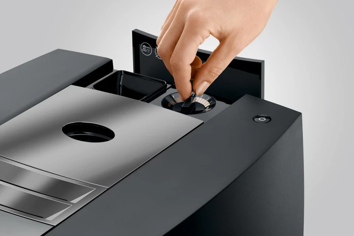 Ekspres Jura J10 w kolorze Piano Black, prezentacja regulacji grubości mielenia ziarna na postoju