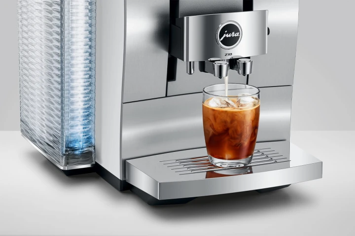 Ekspres Jura Z10 w kolorze białym z aluminium, widok na wylewkę zaprezentowaną ze szklanką kawy Cold-brew