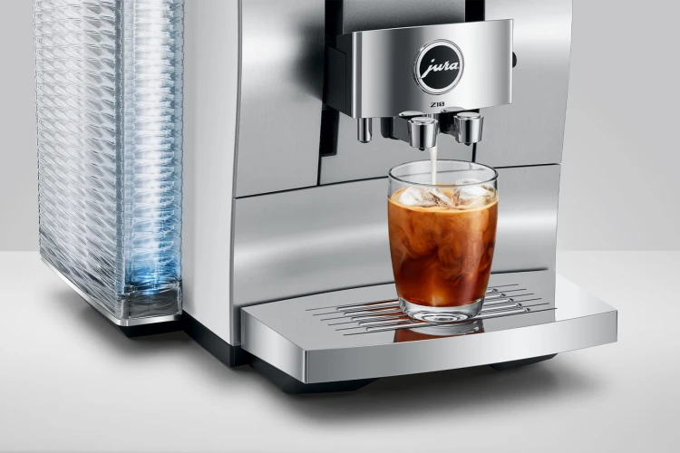 Ekspres Jura Z10 w kolorze białym z aluminium, widok na wylewkę zaprezentowaną ze szklanką kawy Cold-brew