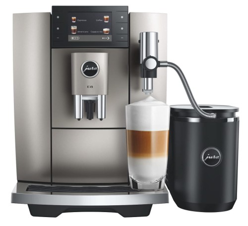 Ekspres Jura E8 ED w kolorze Midnight silver - srebrnym, zaprezentowany ze szklanką kawy latte macchiato oraz czarną chłodziarką Cool Control