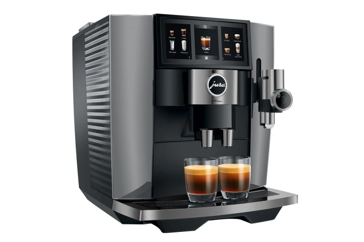 Ekspres Jura J10 Twin w kolorze Diamond Onyx, zaprezentowany od lewej strony, z widokiem na zbiornik wody i z dwiema kawami espresso